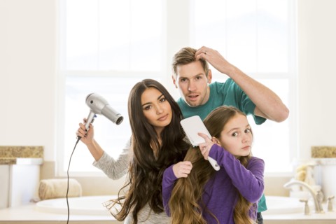 Family grooming hair in bathroom