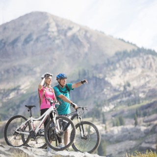 Caucasian couple standing with mountain bikes