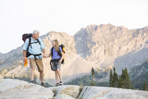 Caucasian grandfather and granddaughter hiking on mountain