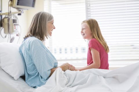 Caucasian granddaughter visiting with grandmother in hospital