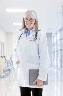 Portrait of smiling Caucasian doctor holding digital tablet