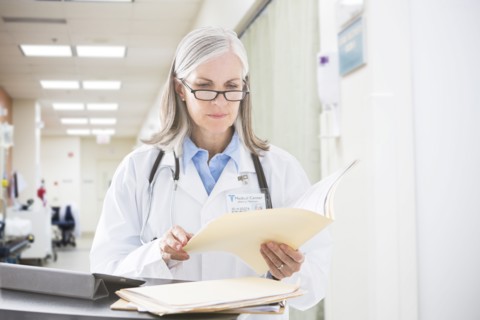 Caucasian doctor reading files in hospital