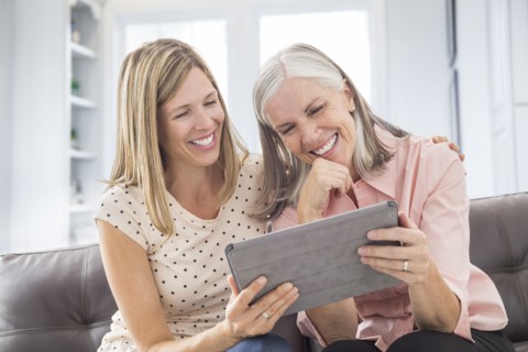 Smiling Caucasian women using digital tablet