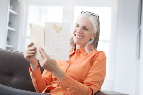 Caucasian women reading greeting card