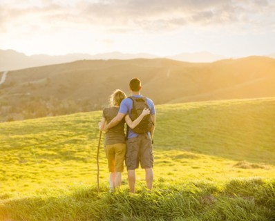 Caucasian couple hugging on hill