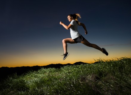Caucasian woman running at sunset