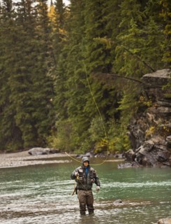 Caucasian man casting in river