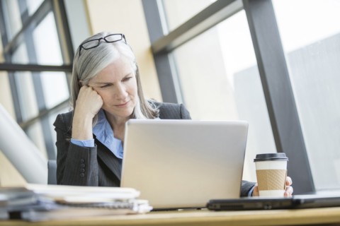 Frustrated Caucasian businesswoman using laptop