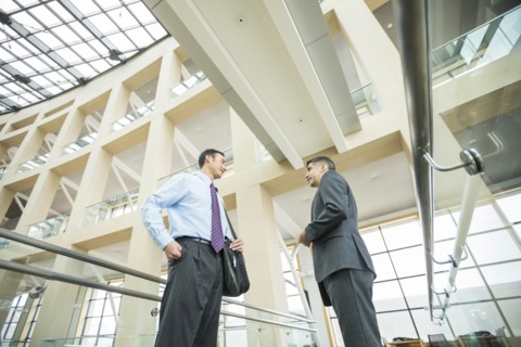 Smiling businessmen talking in lobby