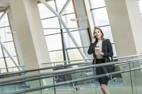 Mixed Race businesswoman talking on cell phone in lobby