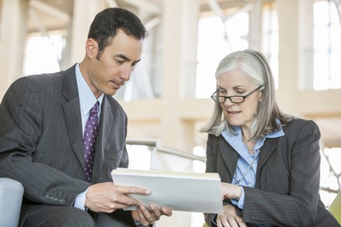 Business people reading paperwork in lobby