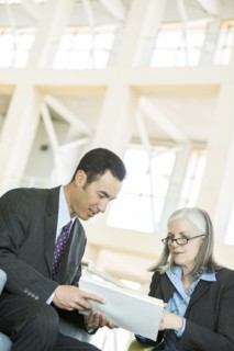 Business people reading paperwork in lobby