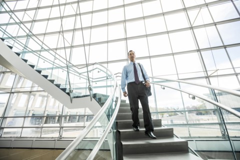 Mixed Race businessman descending staircase