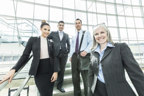 Portrait of smiling business people standing on staircase