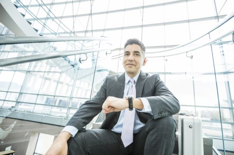 Portrait of smiling Mixed Race businessman sitting on staircase