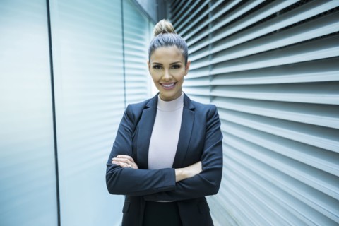 Portrait of smiling Mixed Race businesswoman in corridor