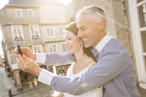 Caucasian couple posing for cell phone selfie
