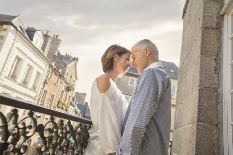 Caucasian couple rubbing your noses on balcony in city