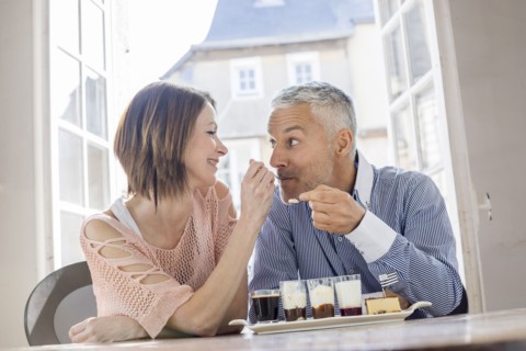 Caucasian woman feeding man dessert in restaurant