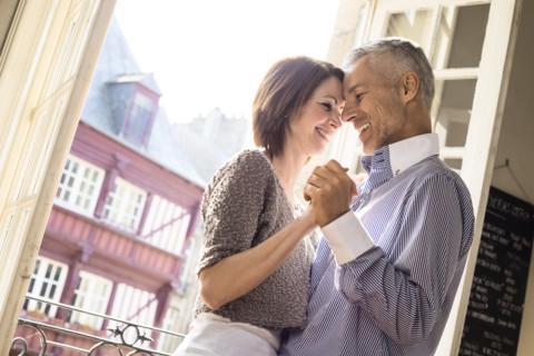 Caucasian couple dancing near doorway
