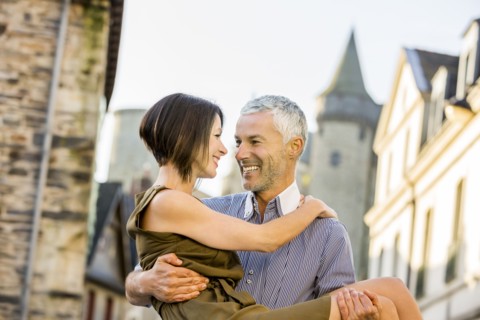 Caucasian man carrying a woman in city