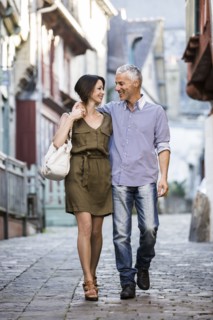 Caucasian couple hugging while walking in city