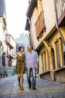 Caucasian couple holding hands walking in city