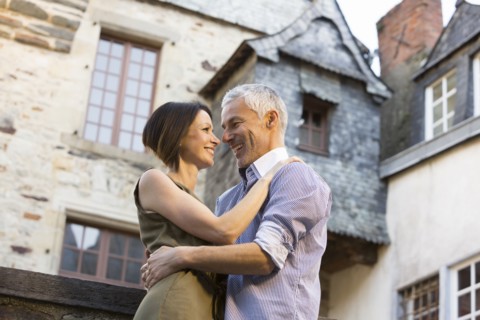 Caucasian couple hugging in city