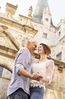 Caucasian couple dancing near building