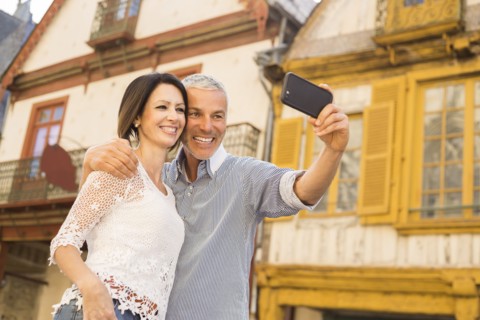 Caucasian couple posing for cell phone selfie