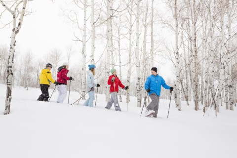 Caucasian family snowshoeing