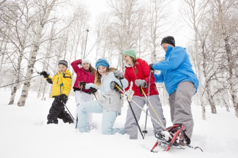Smiling Caucasian family snowshoeing