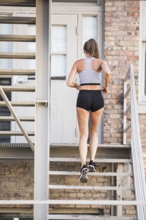 Caucasian woman running on urban staircase