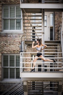 Caucasian woman running on urban staircase