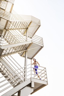 Caucasian woman running on urban staircase