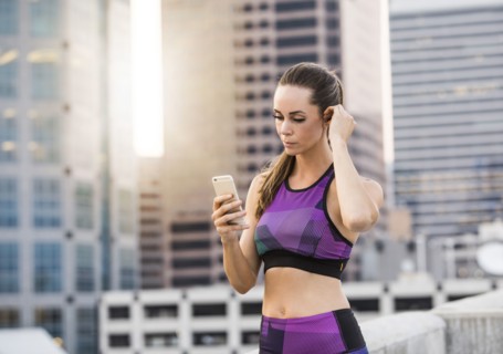 Caucasian woman texting on cell phone on urban rooftop