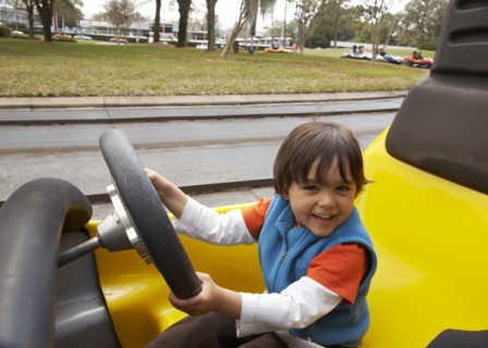 Mixed race boy driving go-cart