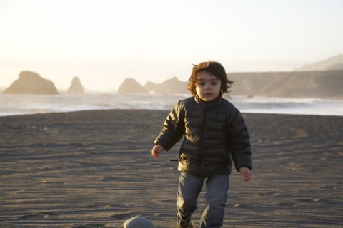 Mixed race boy running on beach