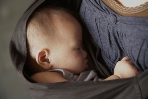 Mother carrying baby in sling