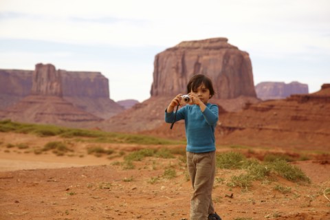 Mixed race boy taking pictures in Monument Valley