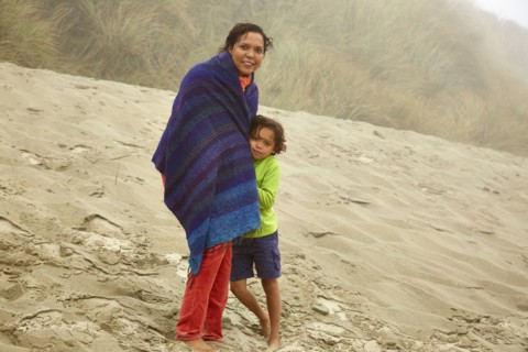 Mixed race mother and son hugging on beach