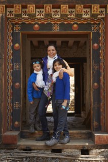Mixed Race mother hugging sons in doorway