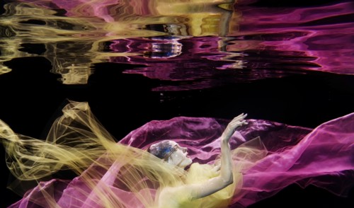 Caucasian woman in scarf swimming under water