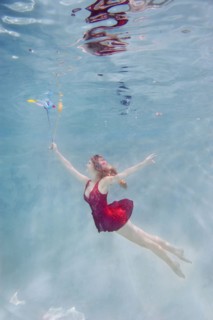 Caucasian woman with balloons underwater
