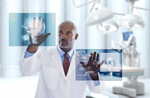 Black doctor looking at digital display in doctor's office