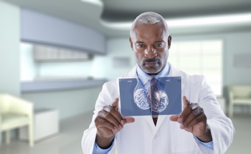 Black doctor using digital display in doctor's office