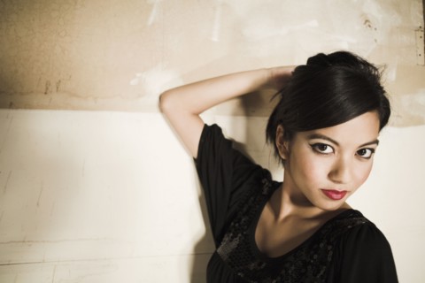 Asian woman with hand on head