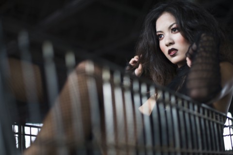 Asian woman sitting in shopping cart