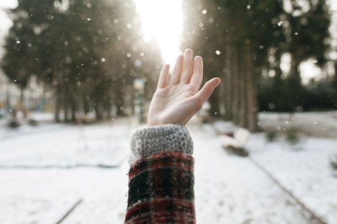 Hand of Caucasian woman catching falling snow