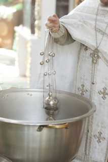 Priest holding chalice in bowl